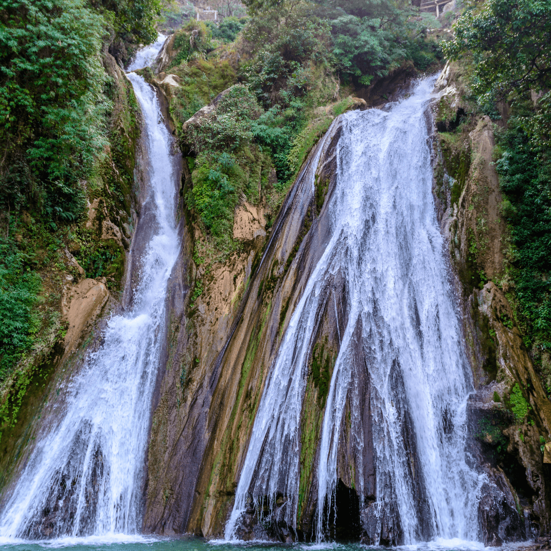 Explore the enchanting Kempty Waterfalls in Mussoorie, where the water cascades down in stunning torrents amidst lush green settings, providing a perfect spot for photography and relaxation.