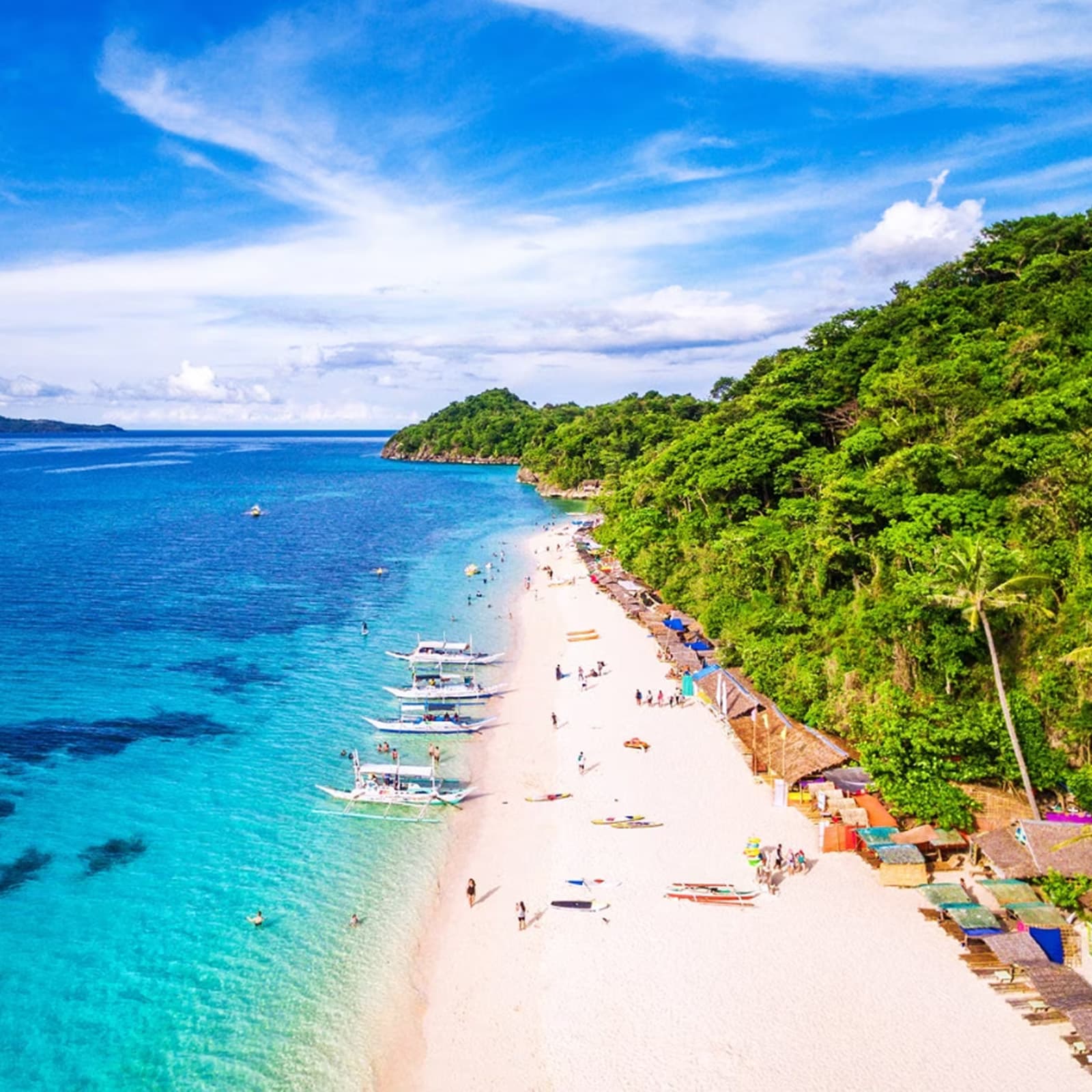 Relax on the pristine sandbar of Nalusuan Island, diving into crystal-clear waters teeming with vibrant marine life, making it an ideal spot for snorkeling and unwinding amidst nature's splendor.